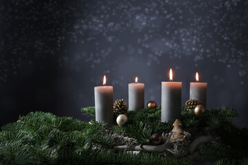 Fourth advent with four burning candles on fir branches with Christmas decoration against a dark...