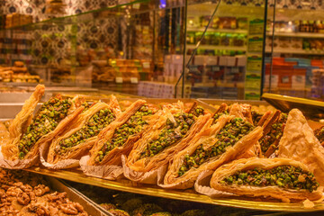 Turkish and Arabic traditional Ramadan dessert - baklava with pistachios. Turkish delight on a stall. Middle east dessert. Turkish Food Culture and Cuisine concept. Edible souvenirs from Turkey.
