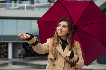 Business woman standing under umbrella on a raining day