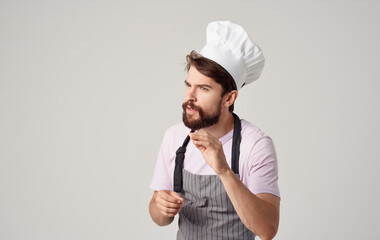 a professional chef in a headdress and an apron gestures with his hands