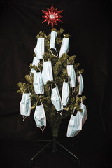 christmas tree decorated with protective masks on a black background
