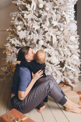 Mom with a small son near a beautiful Christmas tree in his house