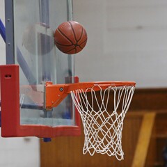 Basketball bouncing against backboard for the score