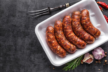 Grilled sausages, homemade,cast iron skillet or frying pan with tomatoes, garlic and rosemary. Brazilian barbecue. copy space