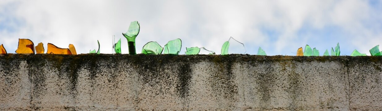 Cristales de botella rotos en lo alto de un muro
