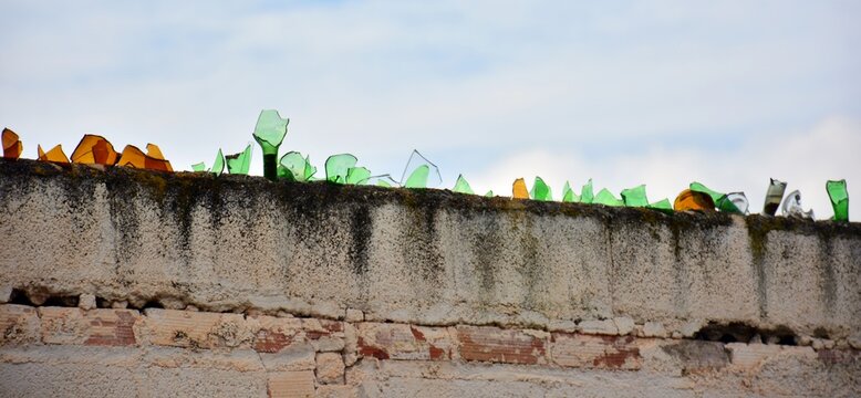 Cristales de botella rotos en lo alto de un muro