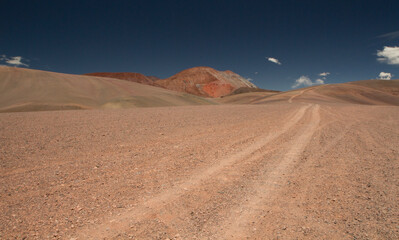 Adventure and explore. Traveling along the dirt road across the arid desert and mountains. View of the extreme route very high in the Andes cordillera. 