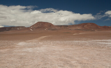 Adventure and explore. Traveling along the dirt road across the arid desert and mountains. View of the extreme route very high in the Andes cordillera. 