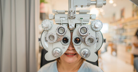 patient checking eyesight value for new eyeglasses with phoropter