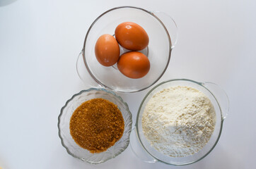 baking ingredients, eggs, flour and brown cane sugar, quarantine home baking concept, food background