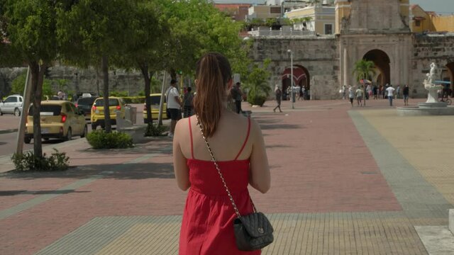 Young Woman in Red Dress exploring old City Cartagena Colombia 