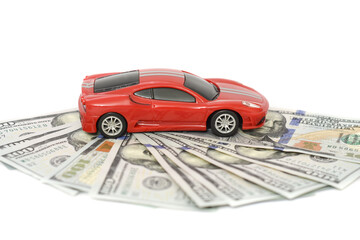 Miniature sports car model near cash money (American dollar bills), isolated on white. Trade car for cash. Insurance, loan and buying car concept