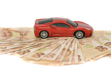 Miniature sports car model on a money road, isolated on white background. Trade car for cash. Insurance, loan and buying car concept
