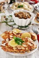Christmas Eve supper with fried carp and other traditional dishes on festive table