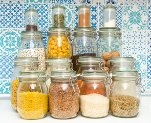 Pandemic pantry with stocked food.  Emergency food prep during Coronavirus Covid-19 for survival. Supplies you need at home if you are quarantined. Prepping for quarantine - glass jars with provision.