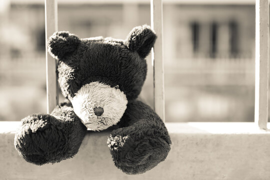 Broken heart or Loneliness concept. black and white image and over ligth of  alone teddy bear with iron cage.  symbol for neglect, sadness, solitary, disappointed.
