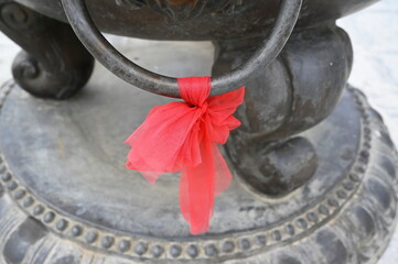 A thin bright red cloth tied to a Circle loop of a large metal censer, symbolizing the prosperity of life. The Chinese believe that red represents power, prestige, holiness and the color of light.
