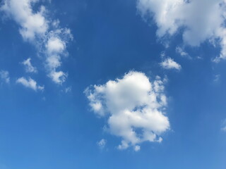 A bright blue sky and white soft clouds scattered in the sky. Picturesque nature, perfect for background pictures
