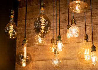 Edison vintage lamps in a glass flask with a tungsten thread inside on a dark background for a...