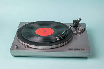 Gray turntable on a light blue background.