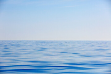 Picturesque blue calm sea against the blue sky. Marine relaxing background.