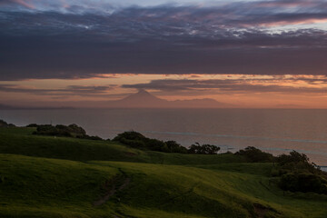 Naklejka na ściany i meble Mt Taranaki sunset view with ocean, clouds and greenland