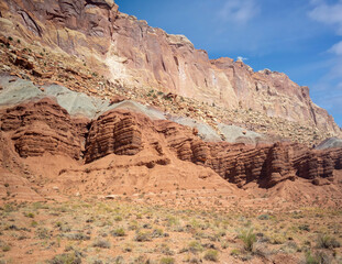Sublime monoliths and towering sandstone cliffs on a hot partly cloudy summer day at Capitol Reef National Park in Southern Utah.