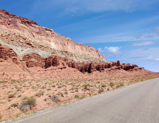 Sublime monoliths and towering sandstone cliffs on a hot partly cloudy summer day at Capitol Reef National Park in Southern Utah.