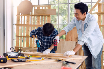 Asian father and son work in carpentry at home.