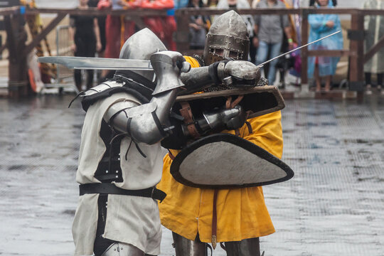 Two knights in medieval armor fight at the festival of historical reconstruction