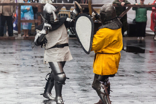 Two knights in medieval armor fight at the festival of historical reconstruction