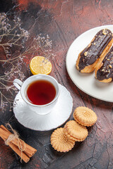 top view cup of tea with cookies and eclairs on a dark background sugar tea biscuit sweet