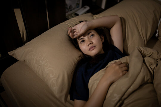 Young asian woman cannot sleep insomnia late at night. Can't sleep. Sleep apnea or stress. Sleep disorder concept.