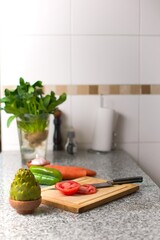 Bell pepper on a cutting board, and fresh ingredients over a kitchen countertop.
