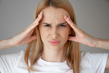 Fototapeta premium Young girl holding her head. Headache