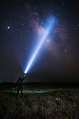 Young Woman illuminates the night sky and milky way with her flashlight Portrait Orientation