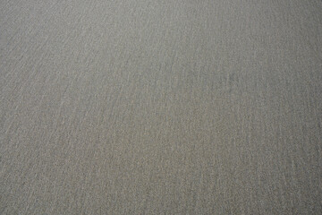 Smooth wet beach sand with faint lines, as a nature background
