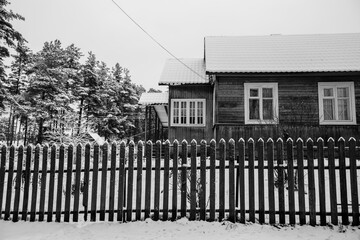 Residential buildings in snowy winter in the village in the nord of Russia. Black and white photo.
