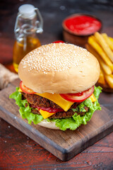 front view meat burger with tomatoes cheese and salad on a dark background bun sandwich fast-food