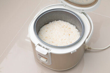 Stream rice in electric rice cooker, close up.