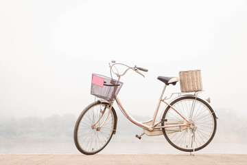 Red bicycle parked on the riverside on nature background.