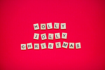 Holly jolly christmas. The inscription from wooden blocks on a bright red background. New Year.