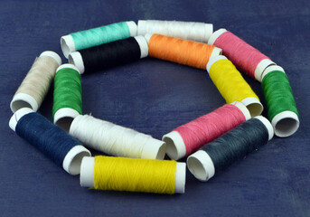 
many threads of different colors lie on a wooden table