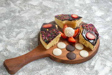 front view delicious cake slices with choco cookies on white background cake dessert sweet