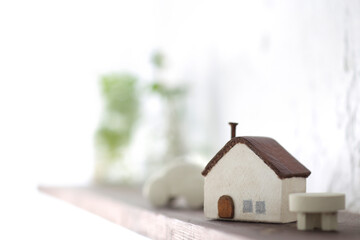 木でできた家の模型とマイホームの設計図のイメージ
