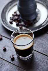 Coffee in glass cup on rustic wooden background. Close up.