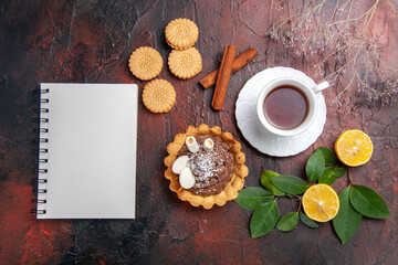 top view cup of tea with little cake and cookies on dark background sweet dessert biscuit