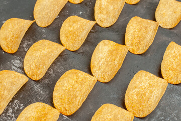 Close up view of snack party for friends with tasty potato chips on gray background
