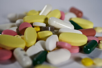 Colored pills, tablets and capsules on a white background. macro photography