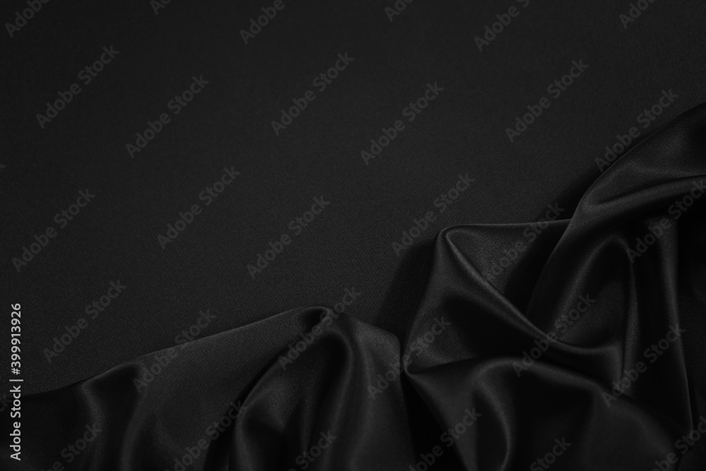 Wall mural black silk satin fabric background. copy space for your design. delicate wavy folds. beautiful elega